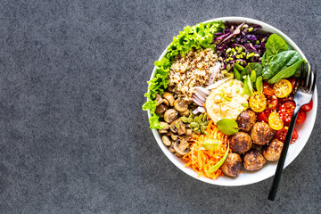 Grilled chicken, rice, spicy chickpeas, avocado, cabbage, pepper buddha bowl on dark background, top view. Delicious balanced food concept