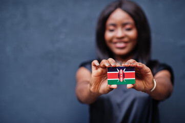 African woman hold small Kenya flag in hands.