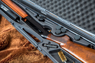 a disassembled 12 gauge hunting shotgun in a gray gun case