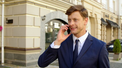 Portrait of angry business man talk mobile phone outdoors. Serious businessman