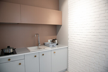 Modern design home interior of kitchen in mansard with elegant accessories. Stylish home decor with white bricks wall.