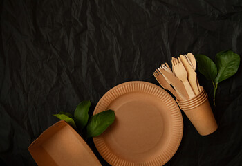 disposable eco tableware made of cardboard spoon fork knife. Place for signature on a black background