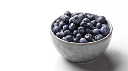 Bowl of fresh ripe blueberries on a white marble background. Healthy seasonal fruit. Organic food blueberries for healthy lifestyle and eating. Vegan, vegetarian concept. Rustic.