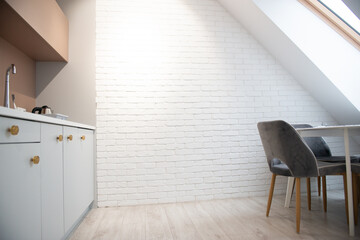Modern design home interior of kitchen in mansard with elegant accessories. Stylish home decor with white bricks wall.