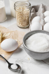 Ingredients and tools for home baking on a culinary background. Eggs, flour, milk, sugar, butter, almond flakes, syrup on the kitchen table. Concept of preparation for baking. Homemade pastry. Cooking