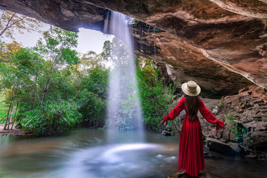 Asian woman standing on the rock at Saeng Chan Waterfall (Long Ru Waterfall), Thailand.