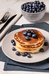 American breakfast. Stack of homemade american pancakes with fresh berry and pouring maple syrup on a white background. Fresh blueberries. Food photo. Breakfast photo. Recipe. Fluffy. Close up view