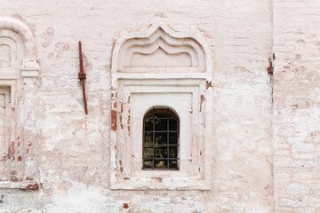 Fototapeta na wymiar Small window in an ancient white stone wall