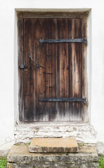 Old brown wooden door in a white wall