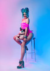 a woman with blue hair and a pink bodysuit is sitting on a bar stool