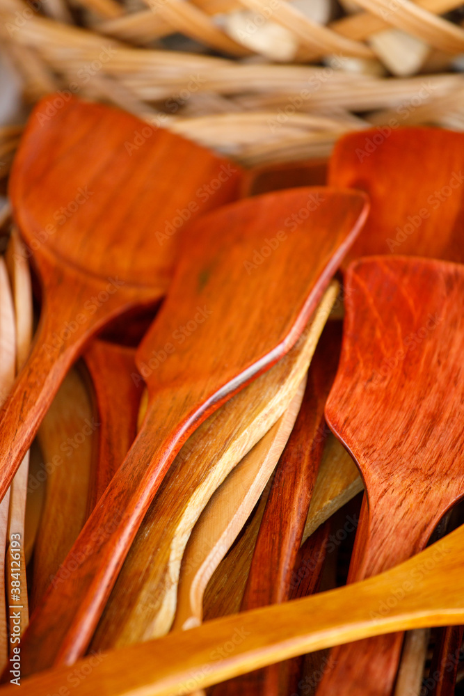 Poster brown wooden spoons lie in a basket.