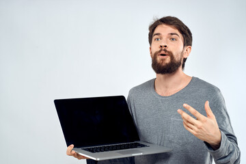 A man in a gray sweater with a laptop hands lifestyle technology communication internet work