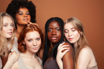 Obraz premium young pretty asian, caucasian, afro woman posing cheerful together on brown background, lifestyle diverse nationality people concept