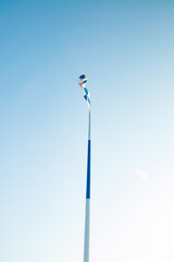 The largest finnish flag in the world and the tallest flagpole in Europe against blue sky, Hamina, Finland. The flag pole is 100 meter high.