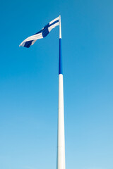 The largest finnish flag in the world and the tallest flagpole in Europe against blue sky, Hamina, Finland. The flag pole is 100 meter high.