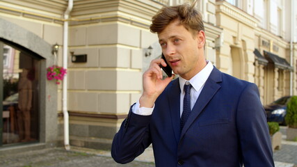 Portrait man talking cellphone at street. Businessman using smartphone outdoors