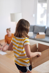 Mother and daughter assembilng new furniture - moving in into a new home.