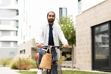Junger Mann mit Fahrrad und Kürbis in einer modernen Wohnanlage