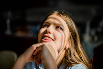 Fototapeta premium Fashion lifestyle image of pretty teenage young woman sitting in kitchen.