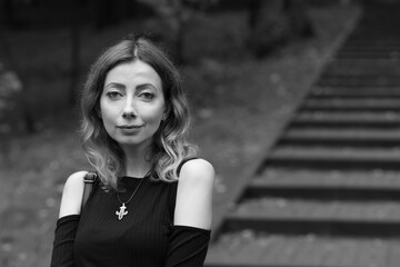 Fototapeta premium Woman on a background of stairs in the park in black and white