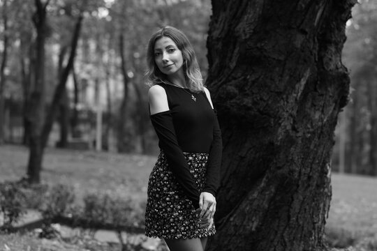 Woman near an old tree in the park in black and white