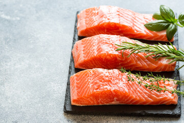 Salmon. Fresh raw salmon fish fillet with cooking ingredients, herbs and lemon. Close up. healthy food, diet or cooking concept