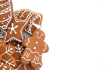 Tasty homemade Christmas gingerbread cookie of various shapes with sugar glaze on white background with copy space