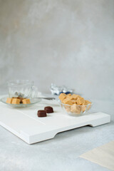 sweet still life of brown cane sugar in a sugar bowl and chocolates on a white tray