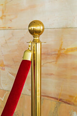 Gold plated rope barrier with red velvet rope