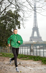 Young woman tourist exercising near river Seine with Eiffel tower on the background. Rain drops is visible