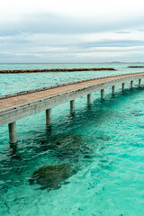 Wooden pier going to horizon in Indian ocean on Maldive islands
