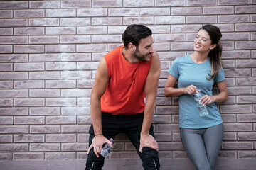 Athletic couple is having a rest after jogging in the city. Happy couple enjoying in the morning...