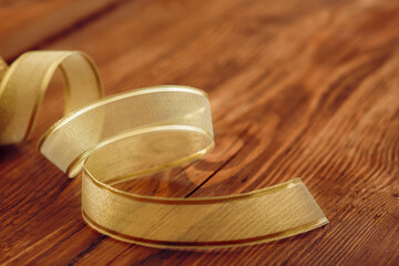 A Golden ribbon spiral on Wooden background