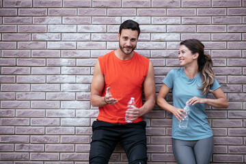 Athletic couple is having a rest after jogging in the city. Happy couple enjoying in the morning...