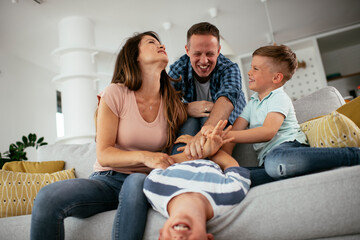 Young family enjoying at home. Happy parents with sons having fun...