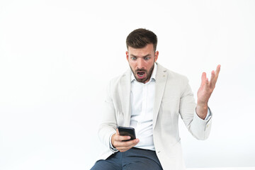Shocked businessman receiving bad news on mobile phone