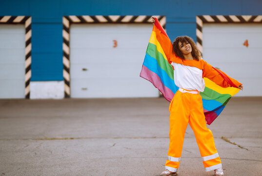 African American lesbian woman holding LGBT rainbow flag.  The concept of happiness, freedom and love for same-sex couples.