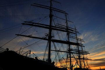 Ship against the backdrop of the sky and the sun. Evening sunset. The image of the ship.
