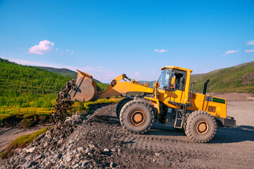 Wheel loader during earthworks in mountainous area - Mining