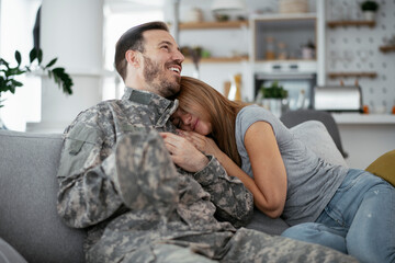 Happy soldier surprise his wife at home. Young soldier hugging wife
