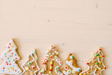 Christmas and New Year traditional attribute, festive sweets for kids, celebration mood. Homemade gingerbread Christmas tree decorated on wooden table.