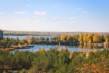 Beautiful old granite quarry with clear water in Indian summer. On the back is the Shershni reservoir. Chelyabinsk, Russia.