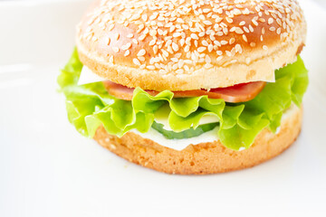 Burger with lettuce and sesame seed bun.