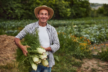 Happy mature gardener with bunch of dill © kegfire