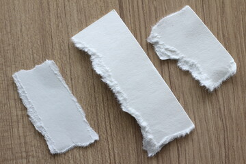 pieces of torn paper on wood background with copy space for text