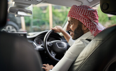 Arabic Muslim businessman driving a car wearing a Keffiyeh