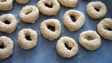 Close-up sesame seeds stuck to the dough, tiny bagels with sesame seeds,
