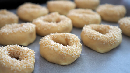 Fototapeta na wymiar Close-up sesame seeds stuck to the dough, tiny bagels with sesame seeds,