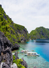 Fototapeta na wymiar Long tail boats floating in turquoise lagoon in El Nido, Philippines