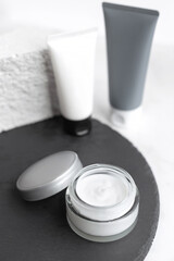 Mock up. Jars, tubes of cream or body lotion, white and gray, on pieces of stone on a white background. Natural eco organic cosmetics. Treatment spa beauty skincare. Healthcare, medicine. Product ad
